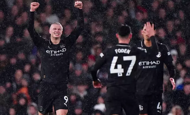 Manchester City's Erling Haaland, lef, celebrates after scoring the opening goal, the 100th goal in his Premier League career, during the English Premier League soccer match between Fulham and Manchester City in London, Tuesday, Dec. 2, 2025. (Bradley Collyer/PA via AP)