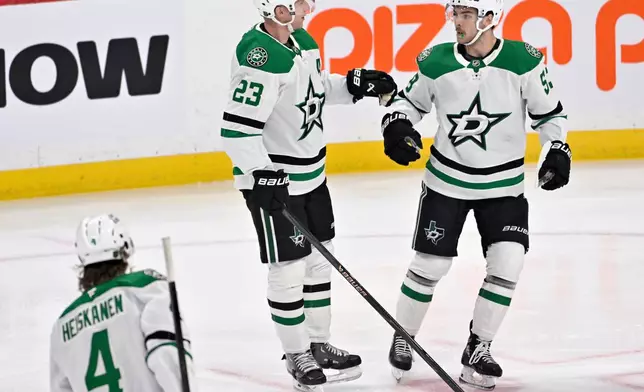 Dallas Stars' Esa Lindell (23) celebrates his goal on the Winnipeg Jets with Wyatt Johnston, right, during the first period of an NHL hockey game in Winnipeg, Manitoba, Tuesday, Dec. 9, 2025. (Fred Greenslade/The Canadian Press via AP)