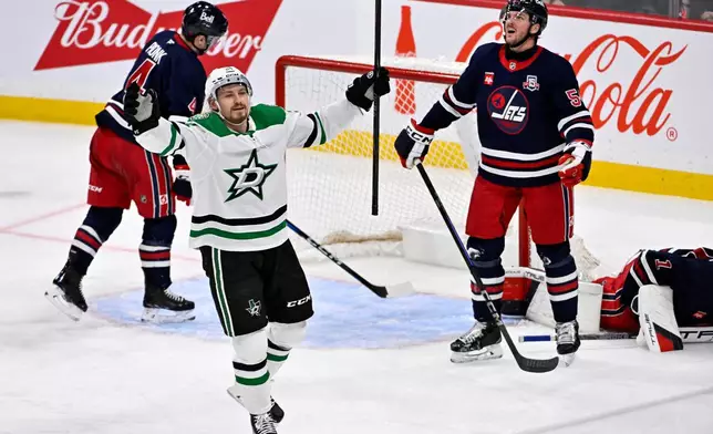 Dallas Stars' Roope Hintz (24) celebrates a goal by teammate Jason Robertson against the Winnipeg Jets during the third period of their NHL hockey game in Winnipeg, Tuesday, Dec. 9, 2025. (Fred Greenslade/The Canadian Press via AP)