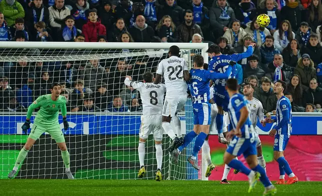 Real Madrid's goalkeeper Thibaut Courtois, left, watches as players challenge for the ball during the Spanish La Liga soccer match between Alaves and Real Madrid in Vitoria-Gasteiz, Spain, Sunday, Dec. 14, 2025. (AP Photo/Miguel Oses)