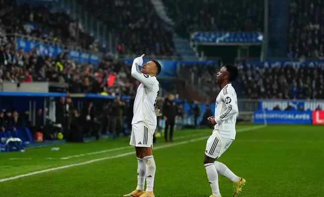 Real Madrid's Kylian Mbappe, left, celebrates with Real Madrid's Vinicius Junior after scoring the opening goal during the Spanish La Liga soccer match between Alaves and Real Madrid in Vitoria-Gasteiz, Spain, Sunday, Dec. 14, 2025. (AP Photo/Miguel Oses)