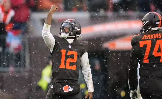 Cleveland Browns' Shedeur Sanders (12) and Teven Jenkins (74) celebrate a touchdown in the first half of an NFL football game against the Tennessee Titans in Cleveland, Sunday, Dec. 7, 2025. (AP Photo/Sue Ogrocki)