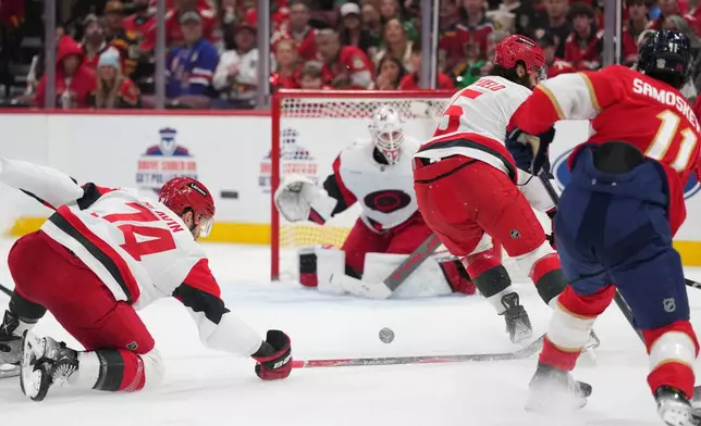 Carolina Hurricanes defenseman Jaccob Slavin (74) blocks the shot of Florida Panthers right wing Mackie Samoskevich (11) during the second period of an NHL hockey game, Friday, Dec. 19, 2025, in Sunrise, Fla. (AP Photo/Jim Rassol)