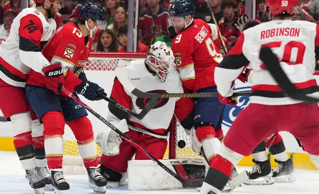 Florida Panthers center Sam Bennett collides into Carolina Hurricanes goaltender Brandon Bussi (32) during the second period of an NHL hockey game, Friday, Dec. 19, 2025, in Sunrise, Fla. (AP Photo/Jim Rassol)