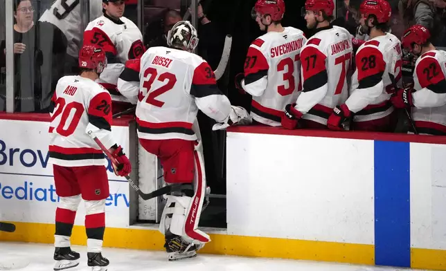Carolina Hurricanes goaltender Brandon Bussi (32) leaves the ice after losing an NHL hockey game in overtime against the Florida Panthers, Friday, Dec. 19, 2025, in Sunrise, Fla. (AP Photo/Jim Rassol)