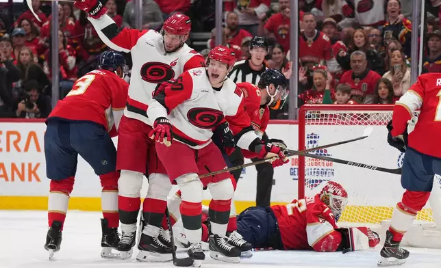 Carolina Hurricanes center Jordan Staal (11) celebrates after a goal with teammate Eric Robinson (50) as Florida Panthers goaltender Sergei Bobrovsky (72) looks on during the first period of an NHL hockey game Friday, Dec. 19, 2025, in Sunrise, Fla. (AP Photo/Jim Rassol)