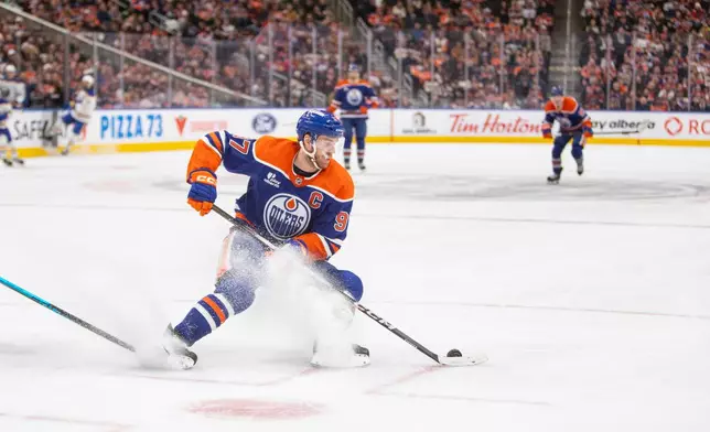 Edmonton Oilers Connor McDavid moves the puck during the second period of an NHL hockey game in Edmonton, Alberta, Tuesday, Dec. 9, 2025. (Amber Bracken/The Canadian Press via AP)