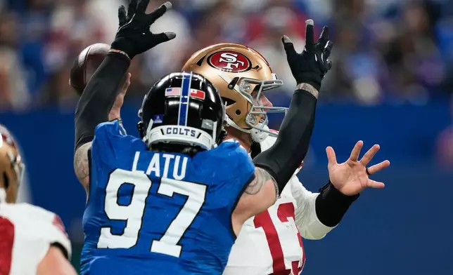 San Francisco 49ers quarterback Brock Purdy, right, is hit by Indianapolis Colts defensive end Laiatu Latu (97) while throwing a pass during the first half of an NFL football game, Monday, Dec. 22, 2025, in Indianapolis. (AP Photo/Carolyn Kaster)