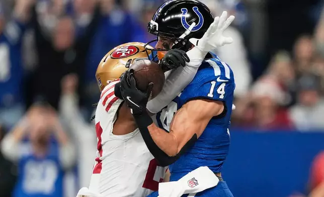 Indianapolis Colts wide receiver Alec Pierce (14) catches a touchdown pass against San Francisco 49ers safety Ji'Ayir Brown during the first half of an NFL football game, Monday, Dec. 22, 2025, in Indianapolis. (AP Photo/Carolyn Kaster)