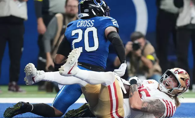 San Francisco 49ers tight end George Kittle, bottom, smiles after catching a touchdown pass against Indianapolis Colts safety Nick Cross (20) during the first half of an NFL football game, Monday, Dec. 22, 2025, in Indianapolis. (AP Photo/AJ Mast)