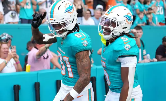Miami Dolphins wide receiver Theo Wease Jr. (81) celebrates with running back Jaylen Wright (5) after scoring a touchdown against the Tampa Bay Buccaneers during the first half of an NFL football game Sunday, Dec. 28, 2025, in Miami Gardens, Fla. (AP Photo/Rebecca Blackwell)