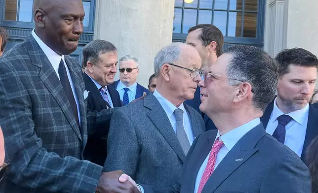 Michael Jordan, left, shakes hands with NASCAR attorney Lawrence Buterman as NASCAR chairman Jim France, center, looks away, Thursday, Dec. 11, 2025, outside the federal courthouse in Charlotte, N.C. (AP Photo/Jenna Fryer)