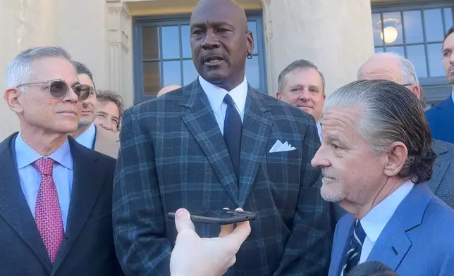 In this image taken from video, Michael Jordan, center, speaks, Thursday, Dec. 11, 2025, outside the federal courthouse in Charlotte, N.C., after NASCAR settled an antitrust lawsuit with two auto racing teams, including one co-owned by Jordan (AP Photo/Jenna Fryer)