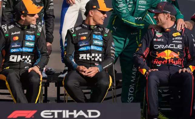 McLaren driver Oscar Piastri of Australia, left, and McLaren driver Lando Norris of Britain, center, and Red Bull driver Max Verstappen of the Netherlands attend the drivers parade ahead of the Formula One Abu Dhabi Grand Prix at the Yas Marina Circuit in Abu Dhabi, UAE, Sunday, Dec. 7, 2025. (AP Photo/Altaf Qadri)