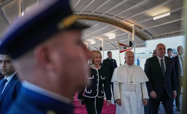 Pope Leo XIV, center right, is escorted by Lebanese President Joseph Aoun, right, and First Lady Nehmat Aoun after his arrival at Beirut International Airport in Beirut, Lebanon, Sunday, Nov. 30, 2025.(AP Photo/Hussein Malla)