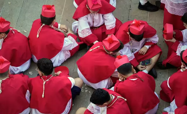 Boys dressed as cardinals wait for the arrival of Pope Leo XIV at the Psychiatric Hospital of the Cross in the town of Jal el-Dib, north of Beirut, Lebanon, Tuesday, Dec. 2, 2025. (AP Photo/Hassan Ammar)