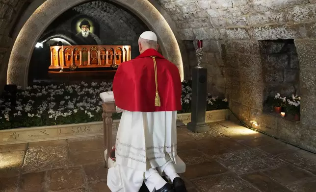 Pope Leo XIV prays in front of the tomb of Saint Charbel Makhlouf at the Monastery of Saint Maroun, in Annaya, Lebanon, Monday, Dec. 1, 2025. (AP Photo/Domenico Stinellis, Pool)