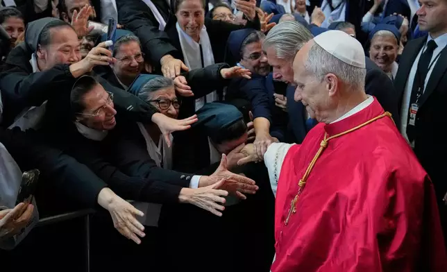 A group of nuns reach out to Pope Leo XIV as he arrives to the Catholic basilica of Harissa, Lebanon Monday, Dec. 1, 2025. (AP Photo/Hussein Malla)