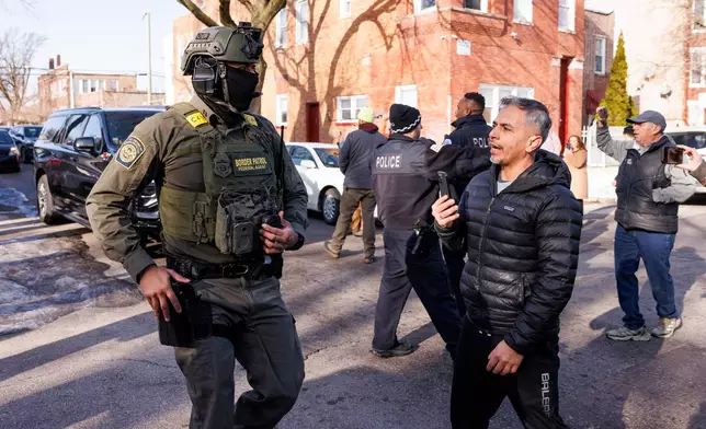 Federal immigration enforcement agents ask to clear the area after they detain an individual at West 27th Street and South Ridgeway Avenue in the Little Village neighborhood of Chicago, Tuesday, Dec. 16, 2025. (Anthony Vazquez/Chicago Sun-Times via AP)