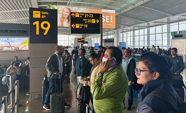 Passengers wait outside the Indira Gandhi International Airport in New Delhi, India, as several Indigo Airlines flights were either cancelled or delayed, Thursday, Dec. 4, 2025. (AP Photo/Manish Swarup)