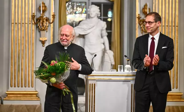 Laszlo Krasznahorkai, Nobel Prize laureate in Literature, is greeted by Mats Malm, Permanent Secretary of the Swedish Academy, after his Nobel Prize lecture in Stockholm, Sweden, Sunday Dec. 7, 2025. (Claudio Bresciani/TT News Agency via AP)