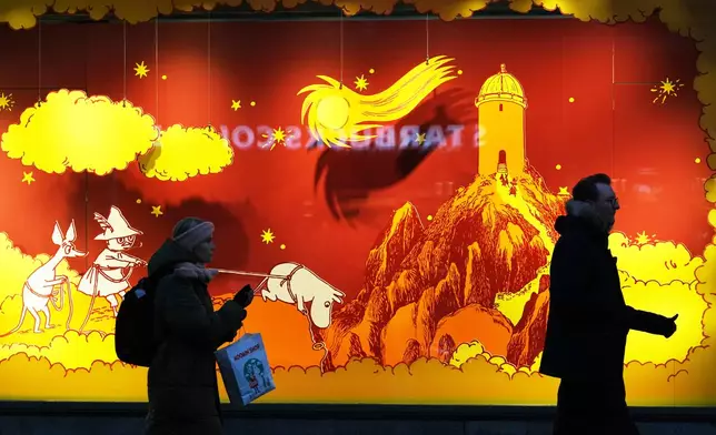 People pass a shop window in Helsinki, Finland, Friday, Nov. 14, 2025. (AP Photo/Sergei Grits)