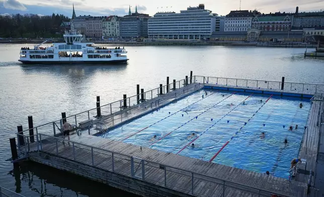 People enjoy in a public pool in Helsinki, Finland, Friday, Nov. 14, 2025. (AP Photo/Sergei Grits)