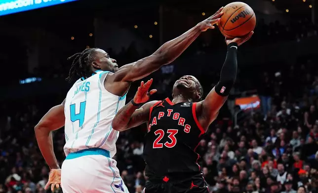 Charlotte Hornets' Sion James (4) strips the ball from Toronto Raptors' Jamal Shead (23) during second half NBA basketball action in Toronto on Friday, Dec. 5, 2025. (Frank Gunn/The Canadian Press via AP)