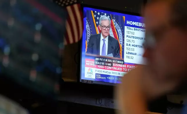 A television displays a news conference with Fed chairman Jerome Powell on the floor at the New York Stock Exchange in New York, Wednesday, Dec. 10, 2025. (AP Photo/Seth Wenig)