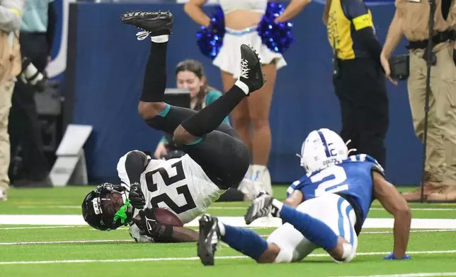 Jacksonville Jaguars cornerback Jarrian Jones (22) tumbles after intercepting a pass intended for Indianapolis Colts wide receiver Josh Downs (2) during the second half of an NFL football game Sunday, Dec. 28, 2025, in Indianapolis. (AP Photo/AJ Mast)