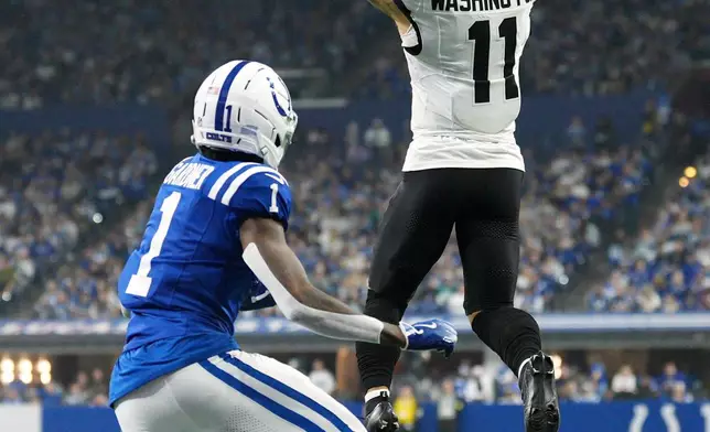 Jacksonville Jaguars wide receiver Parker Washington (11) catches a pass as Indianapolis Colts cornerback Sauce Gardner (1) defends during the first half of an NFL football game Sunday, Dec. 28, 2025, in Indianapolis. (AP Photo/AJ Mast)