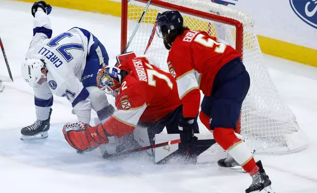 Florida Panthers goaltender Sergei Bobrovsky (72) and defenseman Aaron Ekblad (5) defend the goal against Tampa Bay Lightning center Anthony Cirelli (71) during the first period of an NHL hockey game Saturday, Dec. 27, 2025, in Sunrise, Fla. (AP Photo/Rhona Wise)