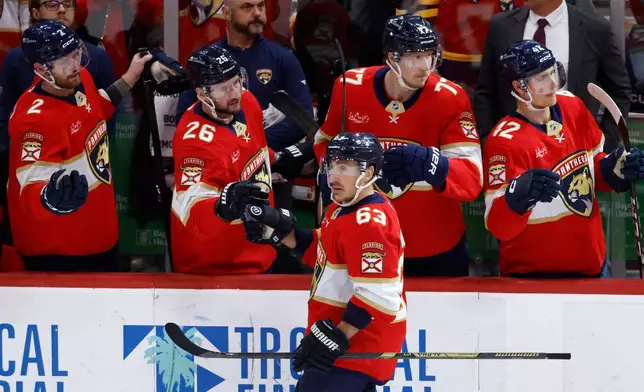 Florida Panthers left wing Brad Marchand (63) celebrates his goal with teammates in the second period of an NHL hockey game against the Tampa Bay Lightning, Saturday, Dec. 27, 2025, in Sunrise, Fla. (AP Photo/Rhona Wise)