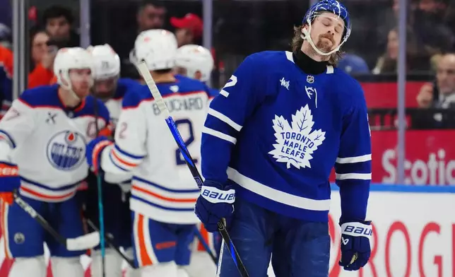 Toronto Maple Leafs' Simon Benoit (2) reacts as Edmonton Oilers players celebrate a goal during the second period of an NHL hockey game in Toronto on Saturday, Dec. 13, 2025. (Frank Gunn/The Canadian Press via AP)