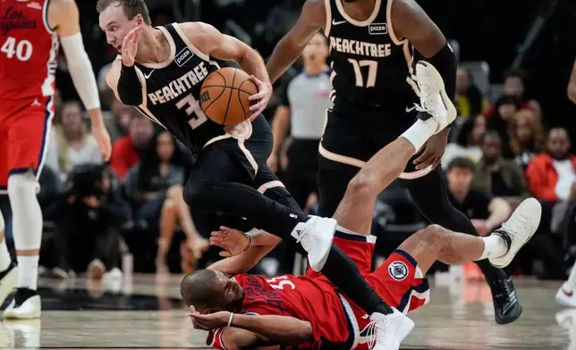 Atlanta Hawks guard Luke Kennard (3) drives against Los Angeles Clippers forward Nicolas Batum (33) during the first half of an NBA basketball game, Wednesday, Dec. 3, 2025, in Atlanta. (AP Photo/Mike Stewart)