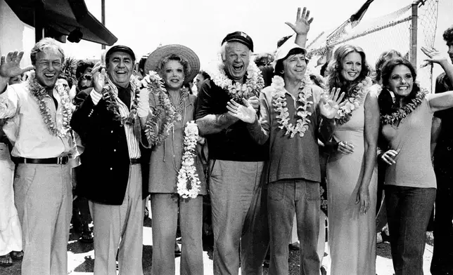 FILE - The cast of "Gilligan's Island," from left, Russell Johnson, as the professor; Jim Backus as Thurston Howell III; Natalie Schafer, as Mrs. Howell III; Alan Hale Jr., as the skipper; Bob Denver, as Gilligan; Judith Baldwin replacing original cast member Tina Louise, as Ginger, and Dawn Wells, as Mary Ann, posing during filming of a two-hour reunion show, "The Return from Gilligan's Island," in Los Angeles, Oct. 2, 1978. (AP Photo/Wally Fong, File)