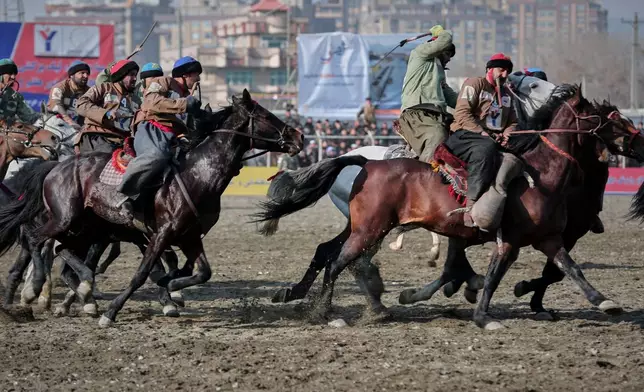 Riders from the Sar-e-Pul and Badakhshan compete in the final of Afghanistan's annual buzkashi tournament, a traditional equestrian sport in which riders score points using a fake goat carcass, on the outskirts of Kabul, Afghanistan, Monday, Dec. 22, 2025. (AP Photo)