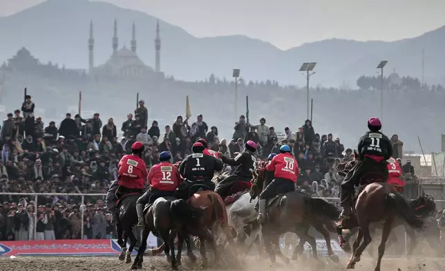 Riders from the Sar-e-Pul and Badakhshan teams compete in the final of Afghanistan's annual buzkashi tournament, a traditional equestrian sport in which riders score points using a fake goat carcass, on the outskirts of Kabul, Afghanistan, Monday, Dec. 22, 2025. (AP Photo)