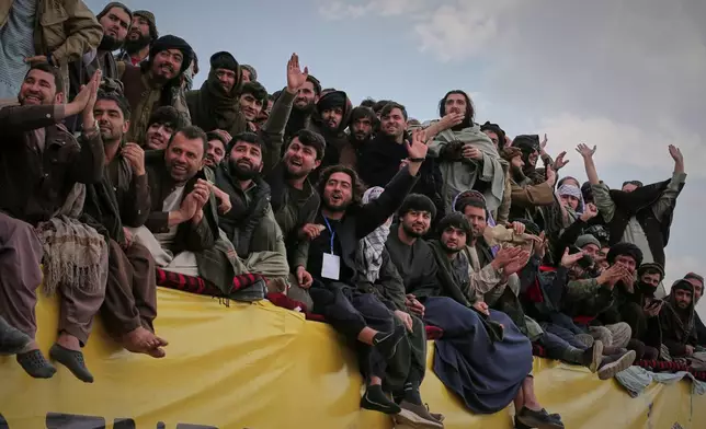Afghan men cheer as they attend the final of Afghanistan's annual buzkashi tournament, a traditional equestrian sport in which riders compete to score points using a fake goat carcass, on the outskirts of Kabul, Afghanistan, Monday, Dec. 22, 2025. (AP Photo)