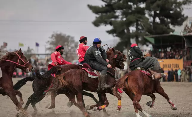 Riders from the Sar-e-Pul and Badakhshan teams compete in the final of Afghanistan's annual buzkashi tournament, a traditional equestrian sport in which riders score points using a fake goat carcass, on the outskirts of Kabul, Afghanistan, Monday, Dec. 22, 2025. (AP Photo)