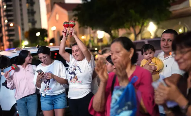 Nicaraguans sing in praise of the Virgin Mary at one of dozens of open-air altars set up near St. John Bosco Catholic Church in celebration of the Dec. 8 feast of the Immaculate Conception, Sunday, Dec. 7, 2025, in Miami. (AP Photo/Rebecca Blackwell)