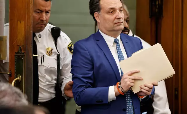 Brian Walshe enter the courtroom clutching papers and a rosary. Opening statements in the Brian Walshe murder trial in Norfolk Superior Court, Dedham, Mass., Monday, Dec. 1, 2025 (Greg Derr/The Patriot Ledger via AP, Pool)