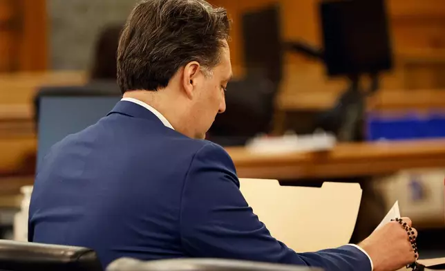 Brian Walsh looks over court papers. Opening statements in the Brian Walshe murder trial in Norfolk Superior Court, Dedham, Mass., Monday, Dec. 1, 2025 (Greg Derr/The Patriot Ledger via AP, Pool)