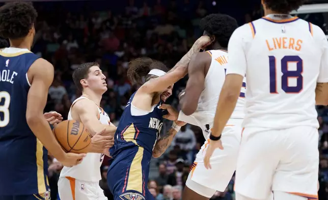 New Orleans Pelicans guard Jose Alvarado, left, and Phoenix Suns center Mark Williams (15) get into a scrum during the third quarter before both were ejected during an NBA basketball game in New Orleans, Saturday, Dec. 27, 2025. (AP Photo/Matthew Hinton)
