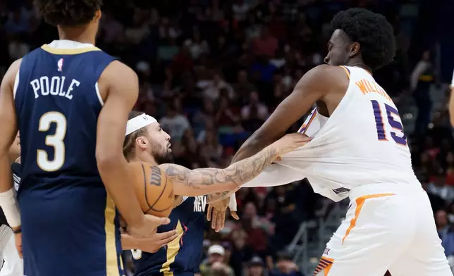 New Orleans Pelicans guard Jose Alvarado, left, and Phoenix Suns center Mark Williams (15) get into a scrum during the third quarter before both were ejected during an NBA basketball game in New Orleans, Saturday, Dec. 27, 2025. (AP Photo/Matthew Hinton)