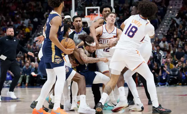 New Orleans Pelicans guard Jose Alvarado (15) and Phoenix Suns center Mark Williams get into a scrum during the third quarter before both were ejected during an NBA basketball game in New Orleans, Saturday, Dec. 27, 2025. (AP Photo/Matthew Hinton)