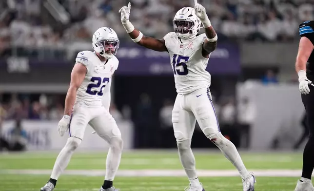 Minnesota Vikings linebacker Dallas Turner, right, celebrates a defensive stop with safety Harrison Smith during the second half of an NFL football game against the Detroit Lions, Thursday, Dec. 25, 2025, in Minneapolis. (AP Photo/Abbie Parr)