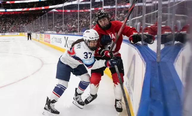 United States' Abbey Murphy (37) checks Canada's Jocelyne Larocque (3) during the third period of a Rivalry Series hockey game in Edmonton, Alberta, Saturday, Dec. 13, 2025. (Jason Franson/The Canadian Press via AP)