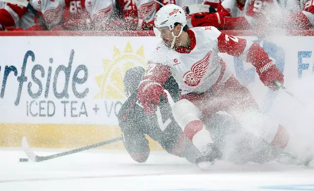 Detroit Red Wings' Mason Appleton, right, collides with Carolina Hurricanes' Nikolaj Ehlers during the first period of an NHL hockey game in Raleigh, N.C., Saturday, Dec. 27, 2025. (AP Photo/Karl DeBlaker)