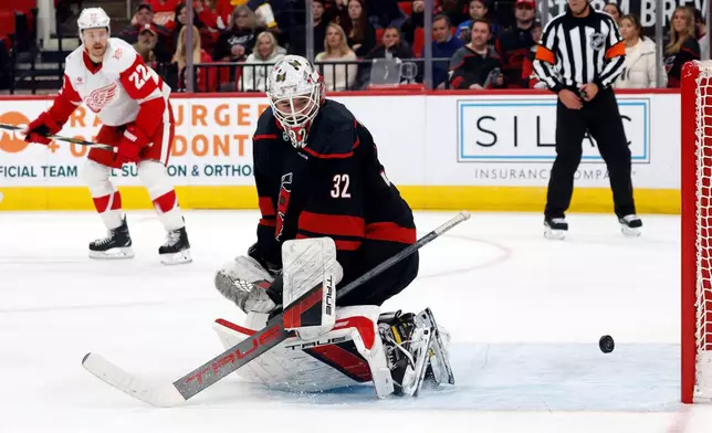 Carolina Hurricanes goaltender Brandon Bussi (32) looks back as the puck comes back out of the net after a goal by Detroit Red Wings' Michael Rasmussen during the first period of an NHL hockey game in Raleigh, N.C., Saturday, Dec. 27, 2025. (AP Photo/Karl DeBlaker)